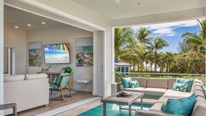 Una sala de estar moderna con piscina, un conjunto de sofás y una televisión.