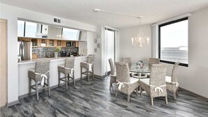 Una cucina moderna con zona bar, sedie da pranzo e un lampadario.