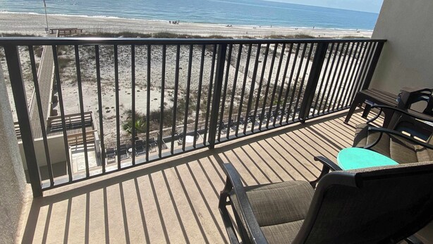 Un balcon avec vue sur la plage et l’océan.