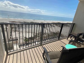 Ein Balkon mit Blick auf Strand und Meer.