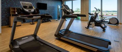 A gym with treadmills, an elliptical, and a rowing machine.