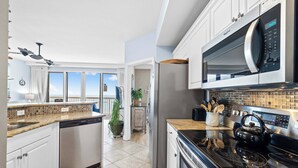 A modern kitchen with stainless steel appliances, a dishwasher, and a microwave. - Waterfront High-Rise PCB Condo w/ Community Perks (Panama City Beach)