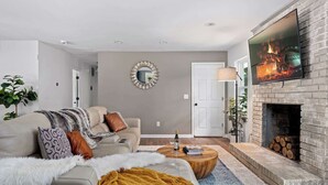 A living room with a sofa, coffee table, and a fireplace. - The Gathering Grove (Tucker)