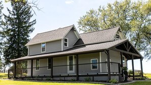 A two-story house with a covered porch and a well-maintained lawn.