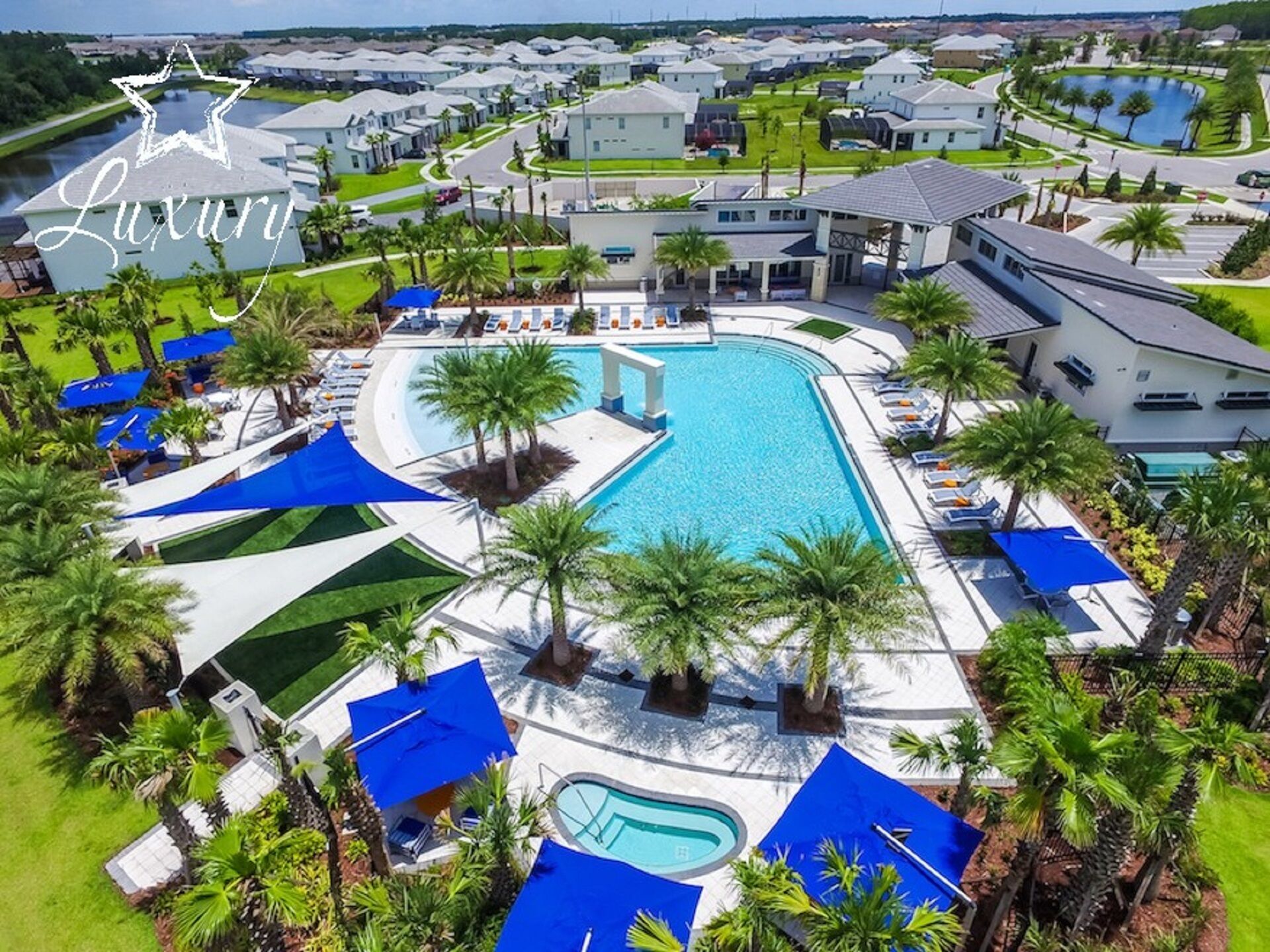 A luxury resort with a large central pool, multiple smaller pools, and a well-maintained landscape with palm trees and blue canopies.