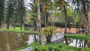 A tranquil park with a pond, lush greenery, and a gazebo. - Incredible country house in Salesopolis (Salesópolis)