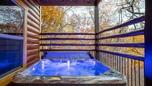 A hot tub in a wooden cabin with a view of autumn trees. - New! “WaterTastic” Private Cabin heated Indoor Pool, Theater, fantastic view  (Gatlinburg)