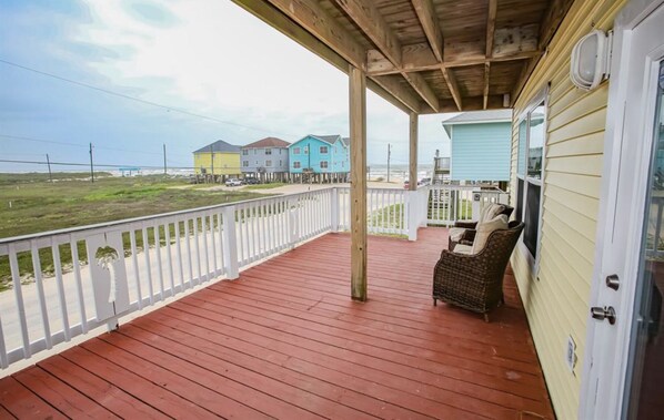 Relax on the covered porch with a wicker chair and enjoy the ocean view.