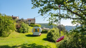 A rural setting with a small white house, a wooden structure, and a red object hanging from a tree. - Relaxing hillside family accommodation with pool (Perugia)