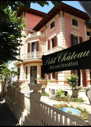 A building with a sign reading "Petit Chateau Bed and Breakfast."