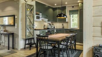 A modern kitchen with a dining area, featuring a wooden table, chairs, and a kitchen island.