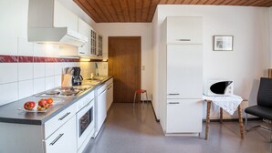 A kitchen with a stove, microwave, and cabinets.