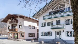 A traditional building with a balcony, a staircase, and a door.