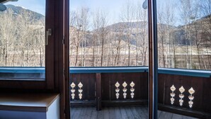 A wooden balcony with a view of a mountainous landscape.