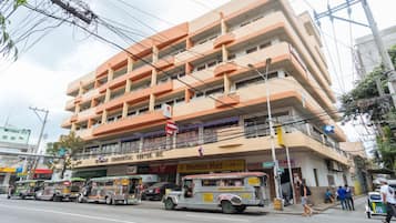 A multi-story building with a commercial ground floor featuring a 'Mightee Mart' and a 'Landbank' sign.