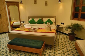 Relax in comfort with a large bed, a wooden bench, and a potted plant.