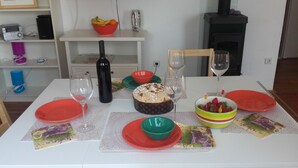 A dining table set with red and green plates, a cake, and a bowl of strawberries. - Holiday Home Pavarotti (Supetar)