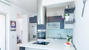 A modern kitchen with a central island, stainless steel appliances, and a microwave above the sink. - Apartments Villa Bella Vista (Orebic)