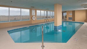 Ein hallenbad mit großen Glaswänden, einem Rettungsring und einer Poolleiter.