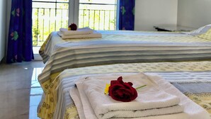 A hotel room with two beds, a balcony, and an air conditioning unit.