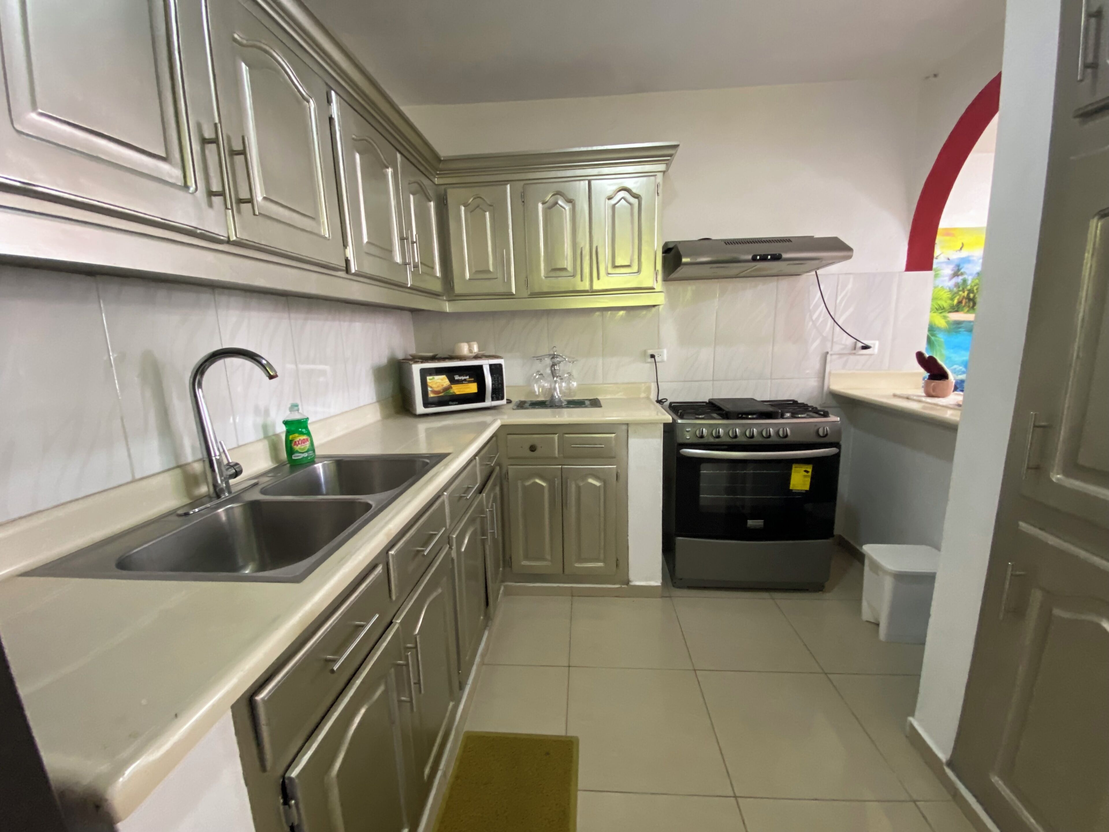 A compact kitchen with stainless steel appliances, a microwave, and a stove.