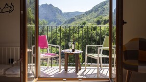 A balcony with a table, two chairs, and a view of a mountainous landscape. - Accessible Rural Apartments La Rioja (Torrecilla en Cameros)