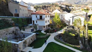 A courtyard with stone walls, a central pathway, and buildings with traditional architecture. - Accessible Rural Apartments La Rioja (Torrecilla en Cameros)