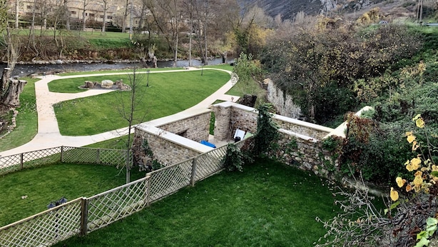 A park with a winding path, stone walls, and a view of a mountain. - Accessible Rural Apartments La Rioja (Torrecilla en Cameros)