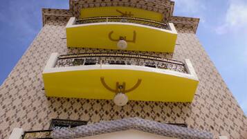 A tall building with a patterned facade and balconies.