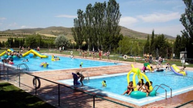 A swimming pool with inflatable play structures and people swimming and playing. - Casa Rural Apartment Sol (Munebrega)
