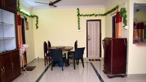 A dining area with a table and chairs, a refrigerator, and a cabinet.