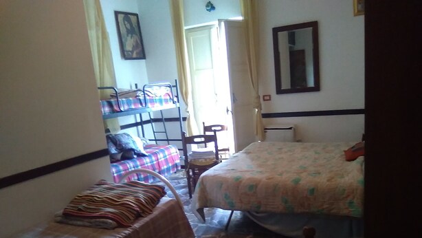 Une petite chambre agréable, dotée de deux lits simples, d’une table avec une chaise et d’une fenêtre avec des rideaux.