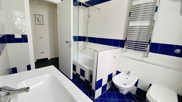 A bathroom with a bathtub, a shower, a sink, and a toilet.
