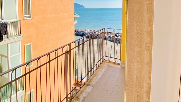 Ein Balkon mit Meerblick und einem entfernten Berg.