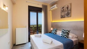 Ett hotellrum med en stor säng, utsikt mot omgivningen, luftkonditionering och en taklampa.