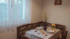 A dining table set with plates, cups, and a vase with flowers.
