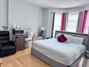 A hotel room with a bed, a desk with a computer, a water dispenser, and a chair. - Room-private 2 Bedrooms, new Shower Bath (North Bergen)