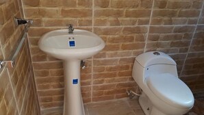 Ein Badezimmer mit einem Waschbecken auf Säule und einer Toilette.