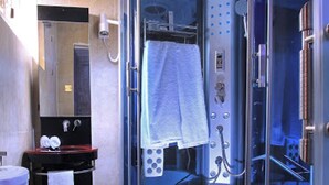 A modern bathroom with a glass-enclosed shower, a toilet, and a sink. - Room-valley Front View Hotel- Guest Room (Lagos)