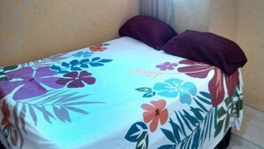A bed with a floral bedspread and two pillows. - Apartahotel Next Nivel - One Bedroom Apartment (Punta Cana)
