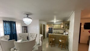 A modern kitchen with a central island, white cabinetry, and a chandelier. - Spacious 3-bedroom Apartment in Santo Domingo! (Santo Domingo Norte)