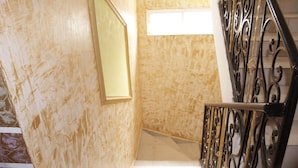 A staircase with a handrail and a wall with a textured finish. - Elu Hotel Studio - Bonamoussadi (Douala)
