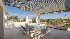 Eine Außenpatio mit Pool, Liegestühlen und einer Hängematte.