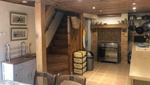 Una cocina con vigas de madera, una estufa y un salpicadero de azulejos.