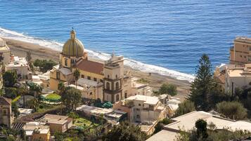 A coastal town with a prominent church featuring a dome, surrounded by residential buildings and a beach.