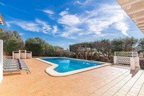 Een buitenzwembad en ligstoelen