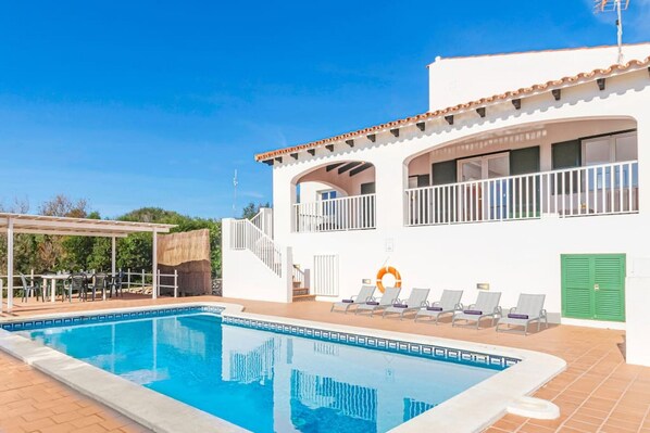 Una piscina al aire libre, tumbonas