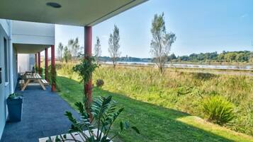 Un espacio exterior techado con vistas a un río y vegetación.