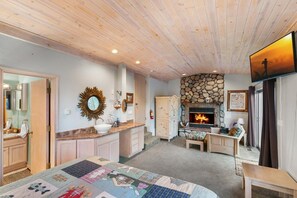 A cozy room with a fireplace, a large mirror, and a bed with a quilt.