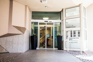 A building entrance with a glass door, a staircase, and a sign indicating 'ERBACHER HOF'. - Erbacher Hof (Mainz)